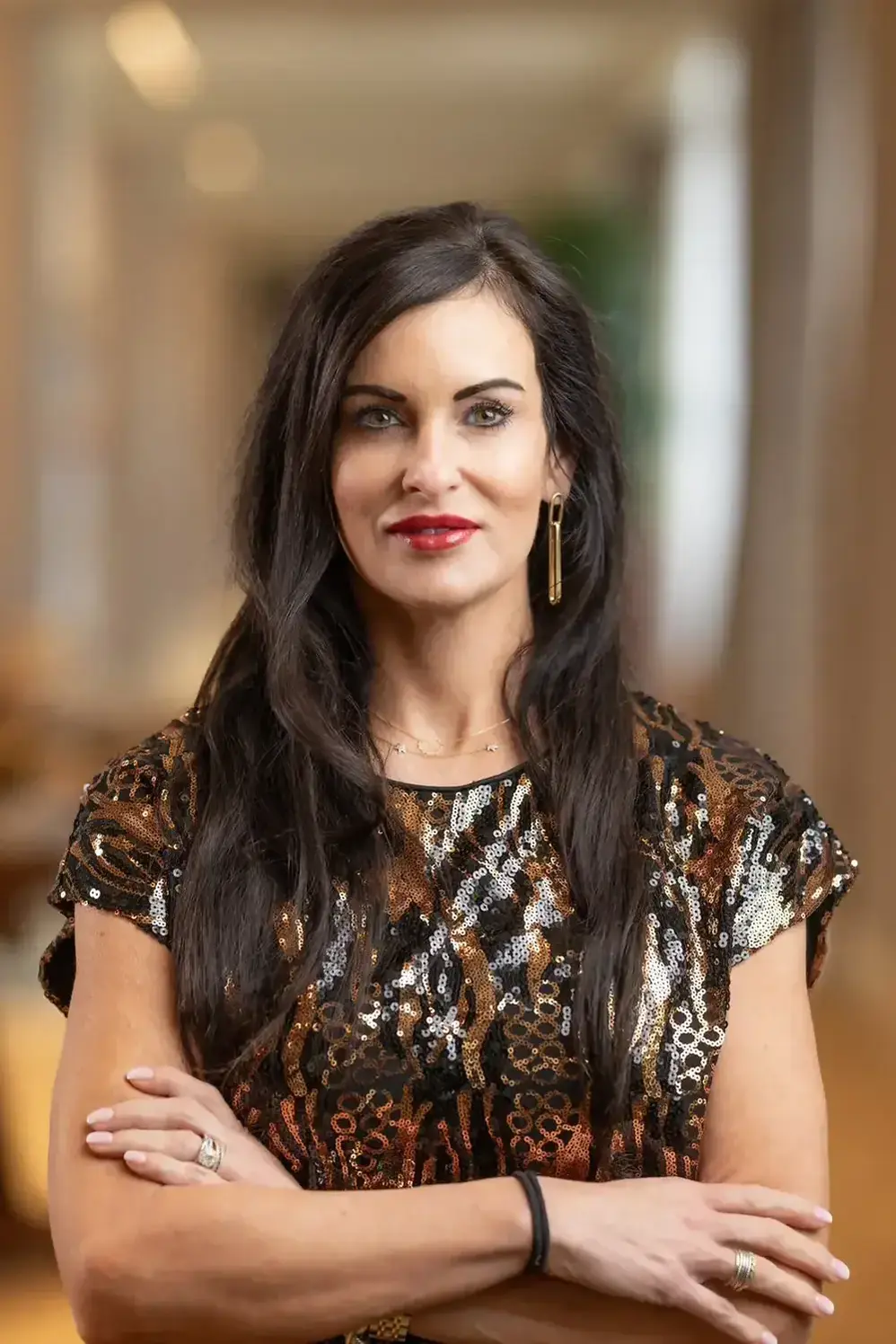 a woman with long hair wearing a gold and black dress