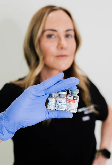 Medical professional wearing a blue glove holding injectable neurotoxin vials | United Medical And Aesthetics in Wilmington, NC